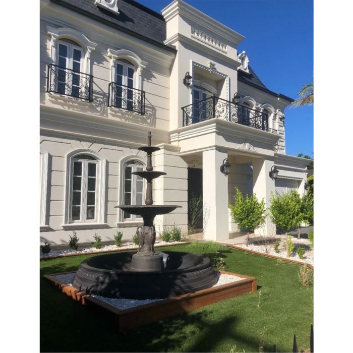 Heron Cast Iron 3 Tier Fountain sits in front of patio