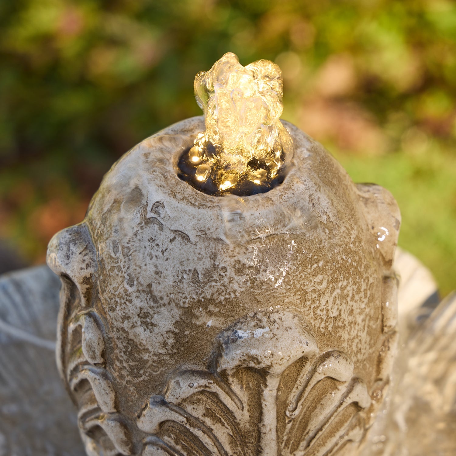 Water bubbling from the top of the fountain with LED
