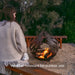 lady sits in front of Corten Steel Fire Bowl – The Phoenix